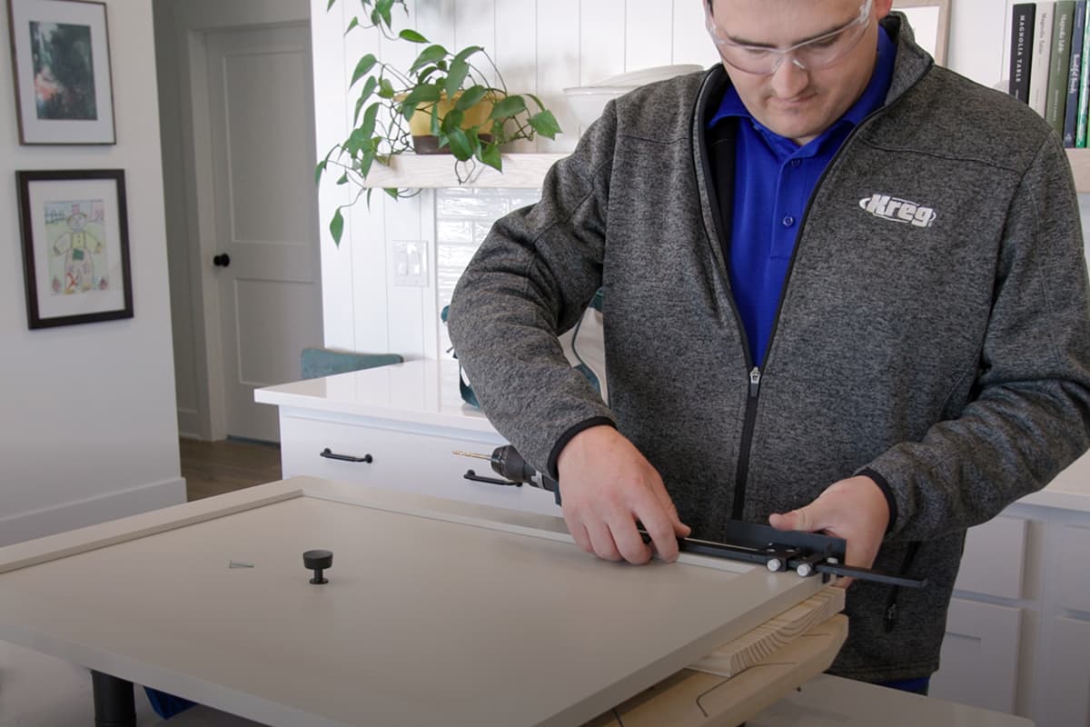 Image of a man installing cabinet hardware